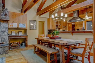 a kitchen with a wooden table and a fireplace at Alpine Meadows Retreat 3 Min to Base with Hot Tub in Alpine Meadows