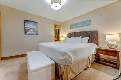 a bedroom with a large white bed and a table at Alpine Meadows Retreat 3 Min to Base with Hot Tub in Alpine Meadows