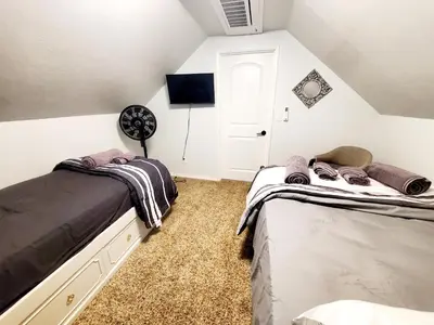 a attic bedroom with two beds and a fan at -Serendipity Lodge at Yosemite- BBQ-Full Kitchen-King Bed in Oakhurst