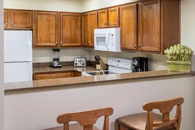 a kitchen with wooden cabinets and two chairs in it at Wyndham South Shore 1Bd- sleeps 4 in Zephyr Cove