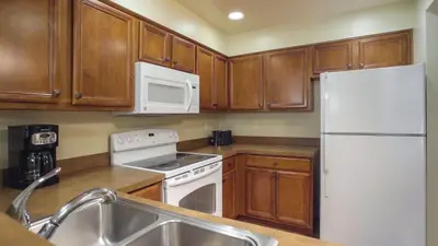 a kitchen with wooden cabinets and a white refrigerator at Worldmark South Shore 1Bd- sleeps 4 in Zephyr Cove