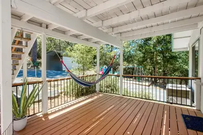 a hammock on a screened porch with a playground at The Valley View- Pine Mountain Lake Cabin home in Groveland