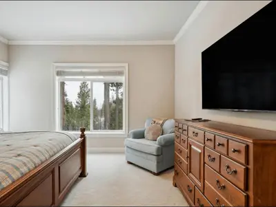a bedroom with a flat screen tv and a chair at The Royal Canterbury Retreat - Near Kings Beach & Lake Tahoe in Kings Beach