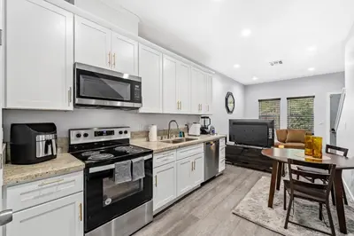 a kitchen with white cabinets and a stove top oven at Cozy 2bdr, 1br home near downtown in Sacramento