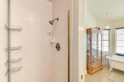 a bathroom with a shower and a tub and a sink at 1 Mi to Applegate Park Zoo Pet-Friendly Home in Merced