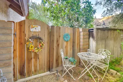 a backyard with a fence with a table and chairs at 1 Mi to Applegate Park Zoo Pet-Friendly Home in Merced