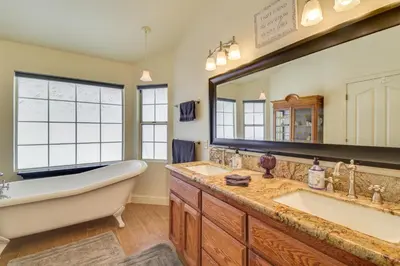 a bathroom with two sinks and a tub and a large mirror at 1 Mi to Applegate Park Zoo Pet-Friendly Home in Merced