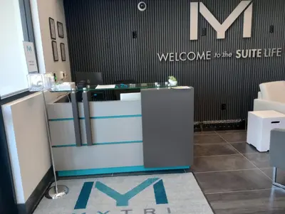 a lobby with a counter with a welcome to the surface life sign at My TRI Suites Reno Sparks in Clark