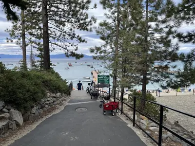 a path leading to a beach with people in the water at Lakeview Cabin in Tahoma