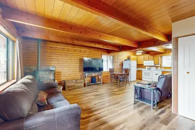 a living room with a couch and a table and a kitchen at Lakeview Cabin in Tahoma