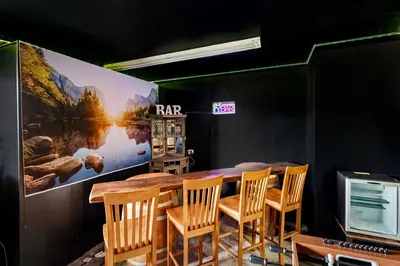 a dining room with a table and chairs and a tv at Pool-GameRoom-HomeTheater-Bar-PlayStructure-FirePit in Oakhurst
