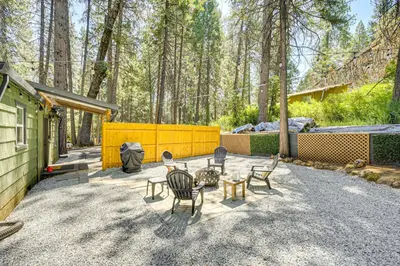 a patio with chairs and a table in a yard at Walk to Winery Cozy Cabin with Fire Pit in Murphys in Murphys
