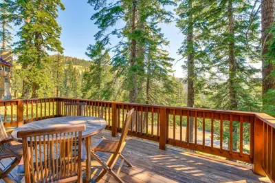 a deck with a table and chairs and trees at Deck with Mountain Views Cabin in Bear Valley! in Bear Valley