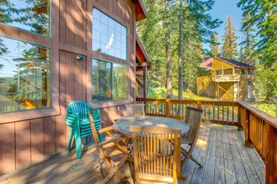 a patio with a table and chairs on a deck at Deck with Mountain Views Cabin in Bear Valley! in Bear Valley