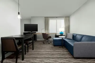 a living room with a blue couch and a table at Residence Inn by Marriott Sacramento Cal Expo in Sacramento