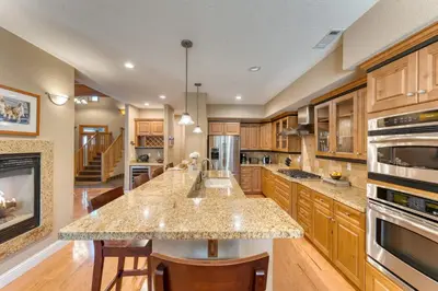 a kitchen with wooden cabinets and a large island at Luxe All-Season Retreat by AvantStay Prime Location Near Skiing in Truckee