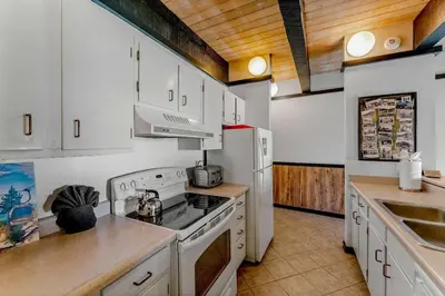 a kitchen with white cabinets and a stove top oven at Lake Tahoe Vacation Rental w Patio & Pool Access in Kings Beach