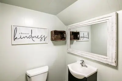 a bathroom with a mirror and a toilet and a sink at Cabin minutes from Yosemite in Fish Camp