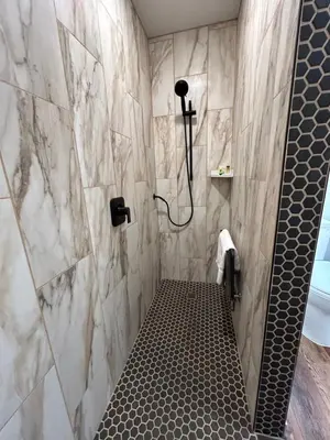 a bathroom with a shower with a black and white tiles at Mi Wuk Village Inn in Mi-Wuk Village