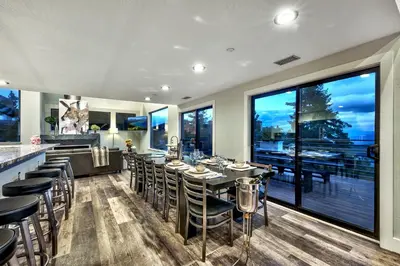 a dining room with a table and chairs and windows at Luxe 4 lake Tahoe Luxury With Hot Tub in Stateline