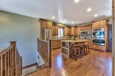 a large kitchen with wooden cabinets and a wooden floor at Lv12 luxury villa with hot tub, close to skiing in Glenbrook