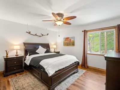 a bedroom with a bed and a ceiling fan at Manzanita Hill-35 miles to Yosemite, 10 miles to Mariposa with 8 person spa in Mariposa