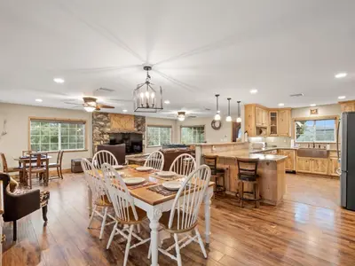 a kitchen and living room with a table and chairs at Manzanita Hill-35 miles to Yosemite, 10 miles to Mariposa with 8 person spa in Mariposa
