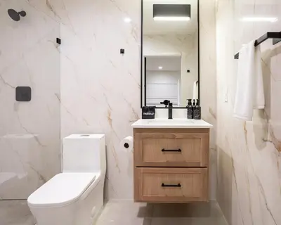 a bathroom with a toilet and a sink and a mirror at Hotel Bayit in Modesto