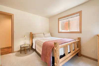 a bedroom with a wooden bed with a window at Landfall on the North Shore - Fenced Yard, Walking Distance to Lake in Kings Beach