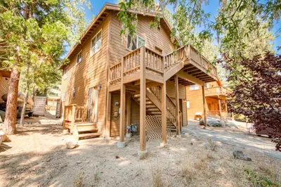 a log cabin with a staircase leading up to a house at Landfall on the North Shore - Fenced Yard, Walking Distance to Lake in Kings Beach