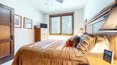 a bedroom with a large bed and a window at Woodwinds #1303 condo in Mammoth Lakes