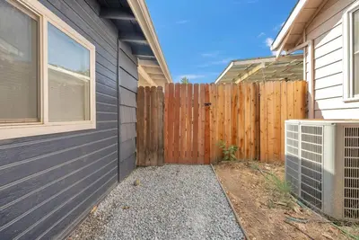 a wooden fence next to a house with a gate at Studio on Main Street in Roseville