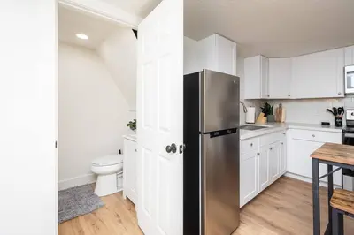 a kitchen with white cabinets and a stainless steel refrigerator at Studio on Main Street in Roseville
