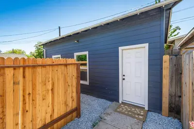 a blue house with a white door and a fence at Studio on Main Street in Roseville