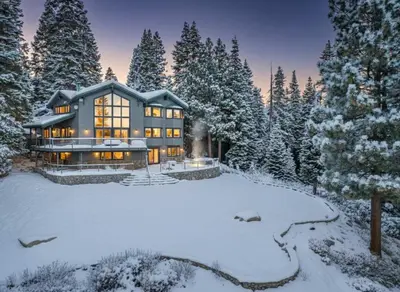 a large house in the snow with trees at Luxury Tahoe Vacation Rental with HotTub & Lake Views in Tahoe Vista