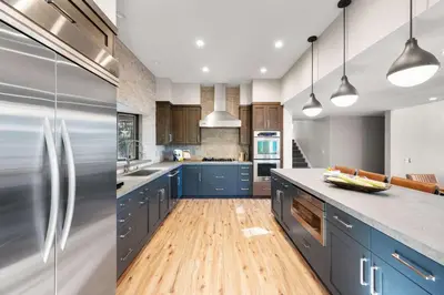 a kitchen with blue cabinets and a stainless steel refrigerator at Luxury Tahoe Vacation Rental with HotTub & Lake Views in Tahoe Vista