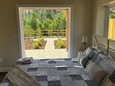 a bedroom with a bed and a large glass door at Ambrosia Hour on the Markleeville River in Markleeville