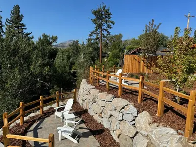 a wooden fence with chairs and a stone wall at Ambrosia Hour on the Markleeville River in Markleeville
