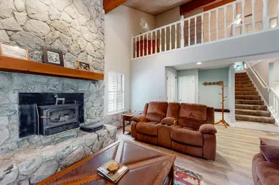 a living room with a couch and a fireplace at Windwood Inn in Shaver Lake