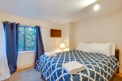 a bedroom with a blue and white bed with a window at Game Rooms, Sauna and Decks South Lake Tahoe Home in South Lake Tahoe