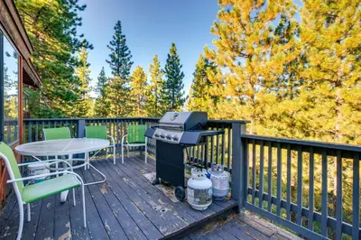 a deck with a grill and a table and chairs at Game Rooms, Sauna and Decks South Lake Tahoe Home in South Lake Tahoe