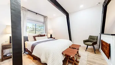 a bedroom with a large bed and a chair at Bigwood #96 condo in Mammoth Lakes