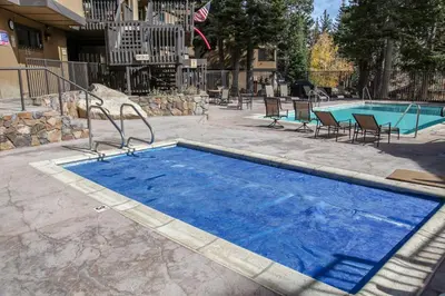 a swimming pool with blue water in a yard at Bigwood #96 condo in Mammoth Lakes