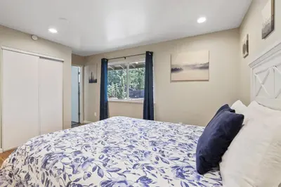 a bedroom with a blue and white bed and a window at Adventure Awaits - Pets - Hot tub - Fire pit in Mevers