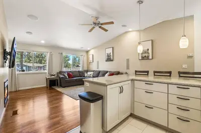 a kitchen and living room with a ceiling fan at Adventure Awaits - Pets - Hot tub - Fire pit in Mevers