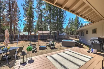 a backyard with a deck with a grill and a table at Adventure Awaits - Pets - Hot tub - Fire pit in Mevers