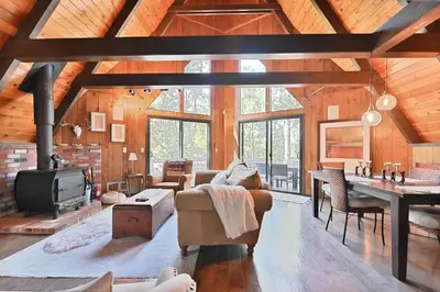 a living room with a couch and a fireplace at Hathaway Pines Hideaway Chalet in Hathaway Pines