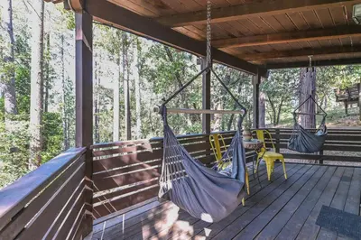 two hammocks on a porch in the woods at Hathaway Pines Hideaway Chalet in Hathaway Pines