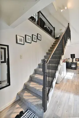 a winding staircase in a home with white walls at Hathaway Hideaway Loft Apartment in Hathaway Pines