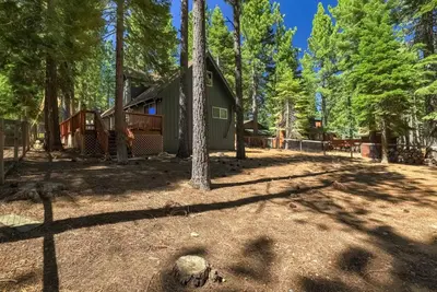 a cabin in the woods with trees in the foreground at Moose Haven - Family Favorite! Close to beaches! in South Lake Tahoe